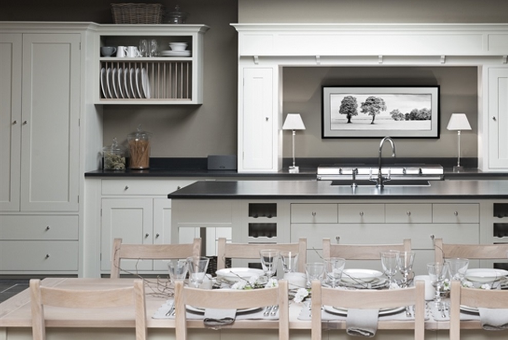 Moderne, helle Landhausküche mit großzügigem Esstisch und stilvoller Dekoration Helle Küche im Landhausstil mit großem Esstisch, Gedecken, Hängeschränken, Arbeitsfläche und Wandbild