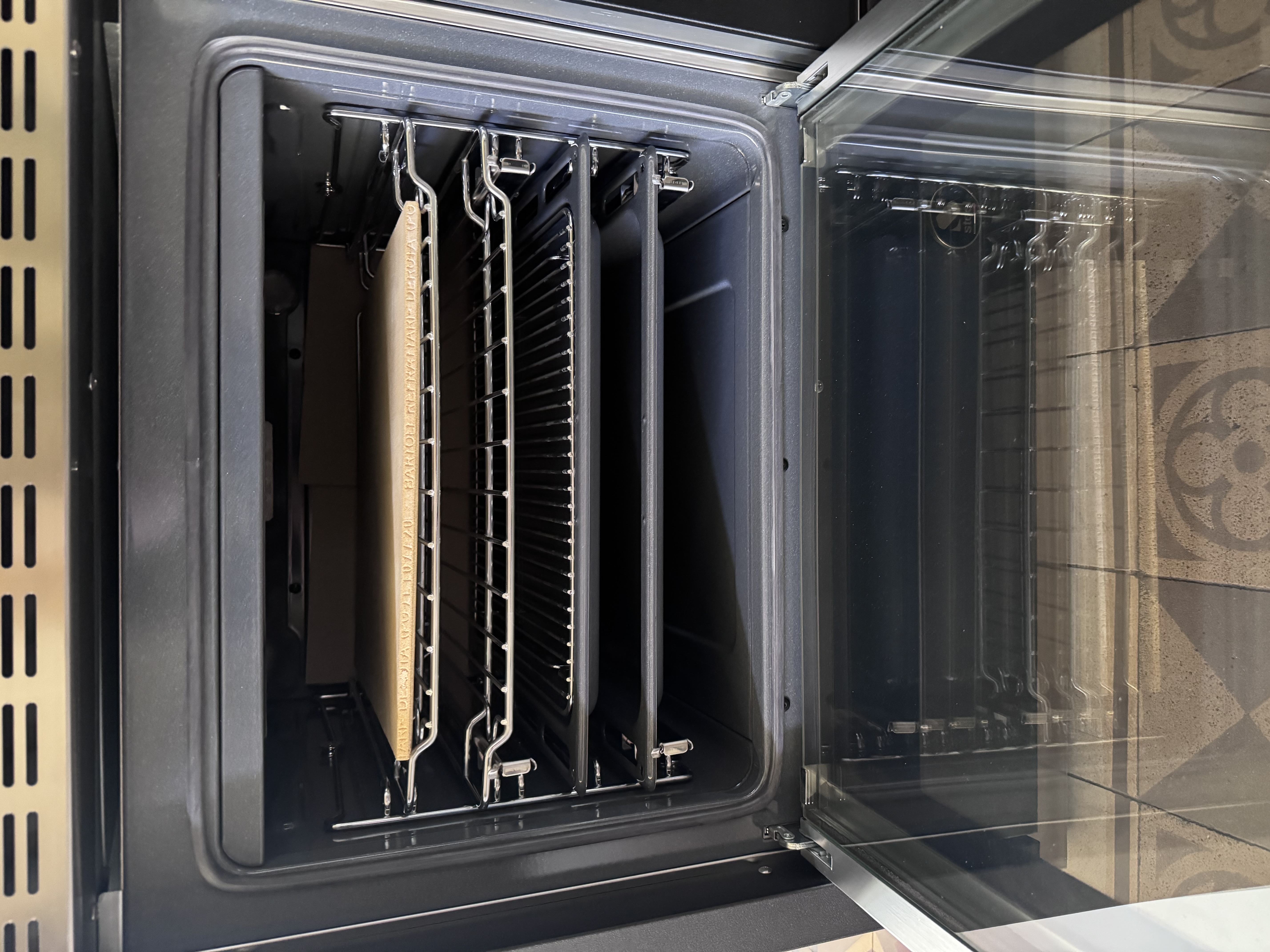 Geöffneter Einbau-Backofen: Innenraum mit Teleskopauszügen, Grillrost und Backblech, leicht zu reinigen und vielseitig nutzbar