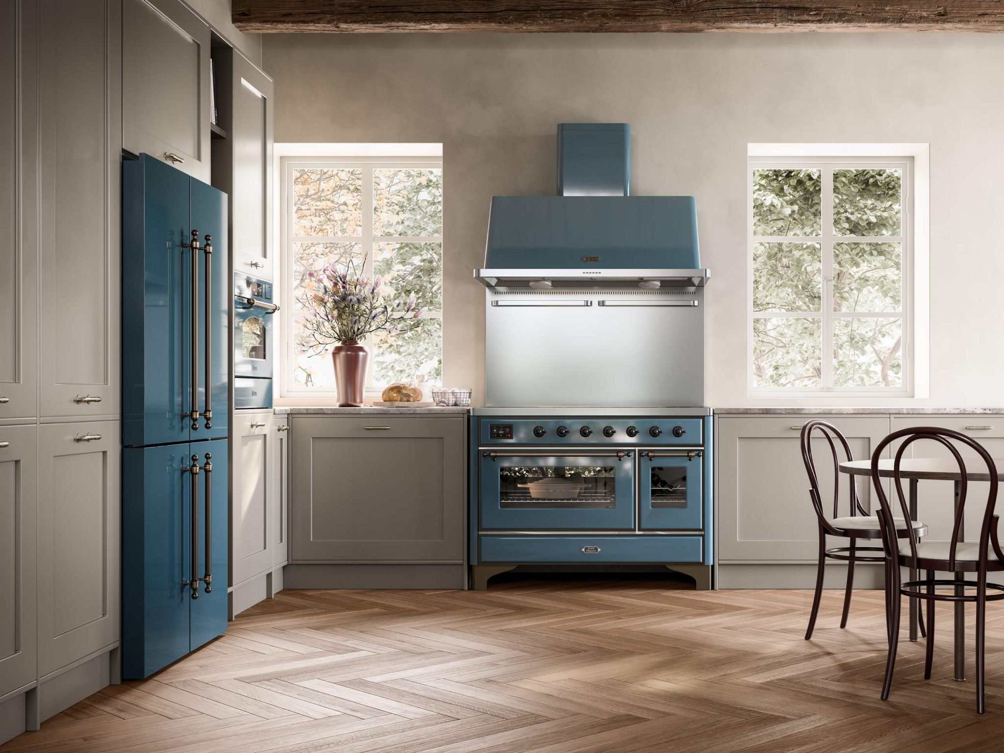 Elegante Einbauküche: graue Rahmenfronten, blauer Herd mit Backofen und Haube, passender Kühlschrank, Stein-Arbeitsplatte, Holzboden im Fischgrät, viel Tageslicht, runder Esstisch mit Stühlen.