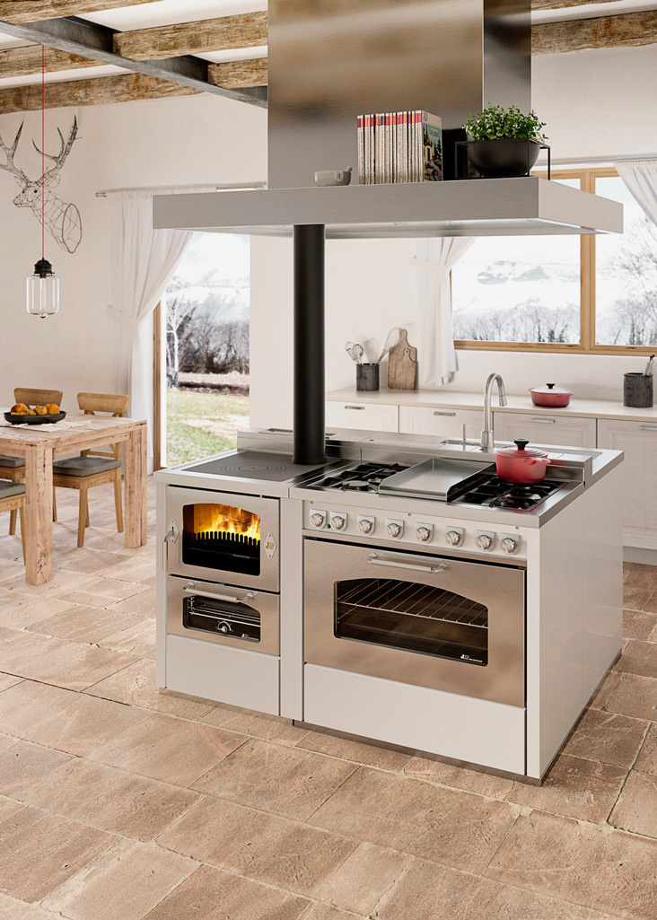 Moderne Kücheninsel mit integriertem Holzofen und Gasherd in heller Landhausküche Kücheninsel mit Holzofen, Gasherd und Backofen in einer hellen, modernen Landhausküche mit Blick auf den Garten