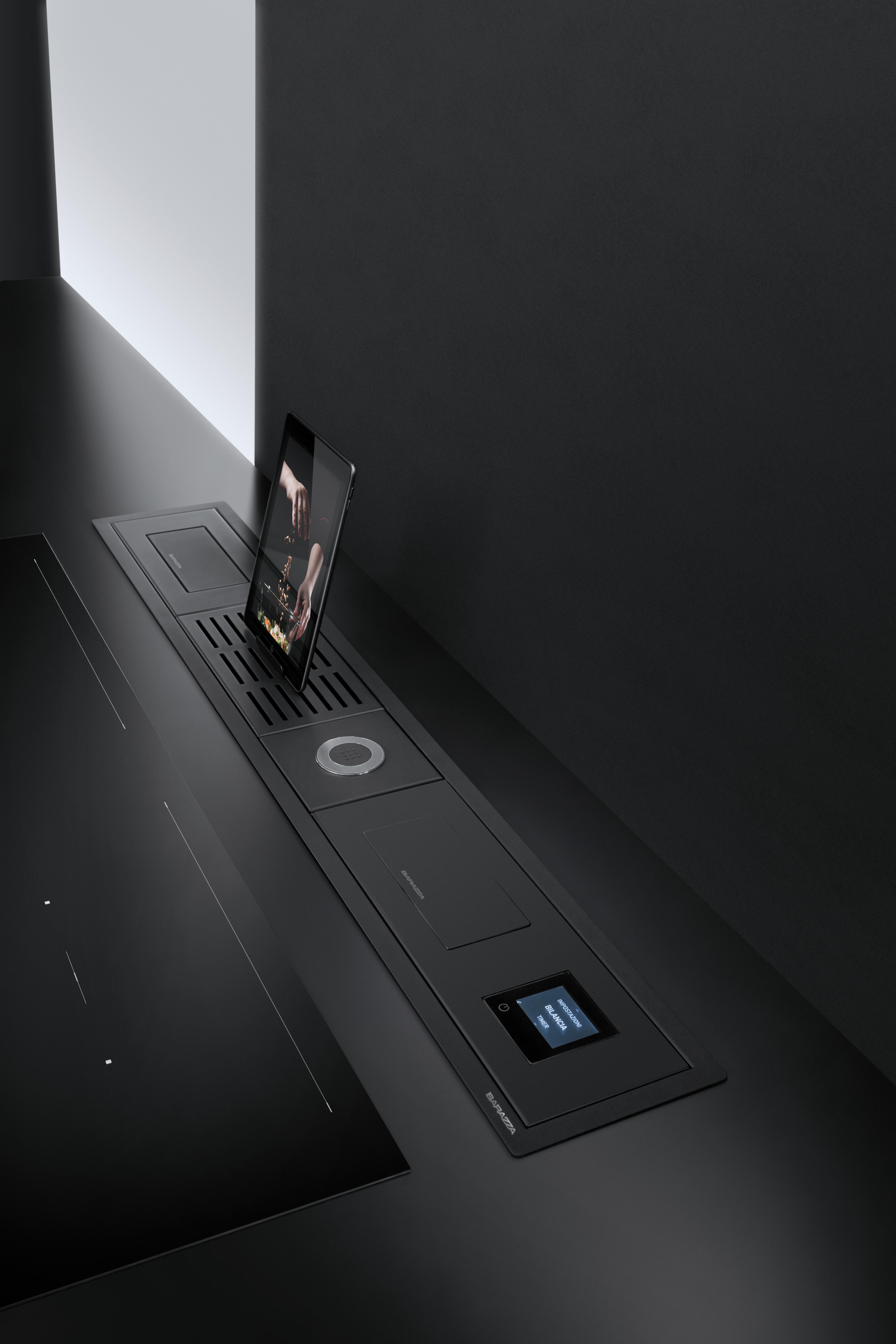 Modernes Kochfeld mit integriertem Dunstabzug, Touchdisplay und Tablet-Halterung in schwarz Schwarzes Kochfeld mit integriertem Dunstabzug, Touchdisplay und einer Halterung für ein Tablet, modernes Küchendesign