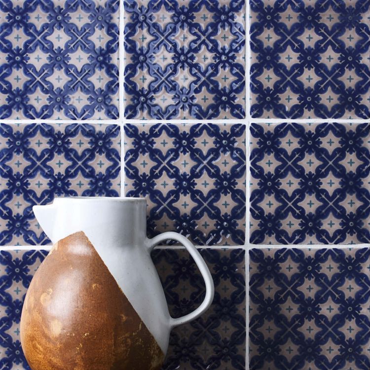 Glänzende blaue Musterfliesen, davor Keramikkrug