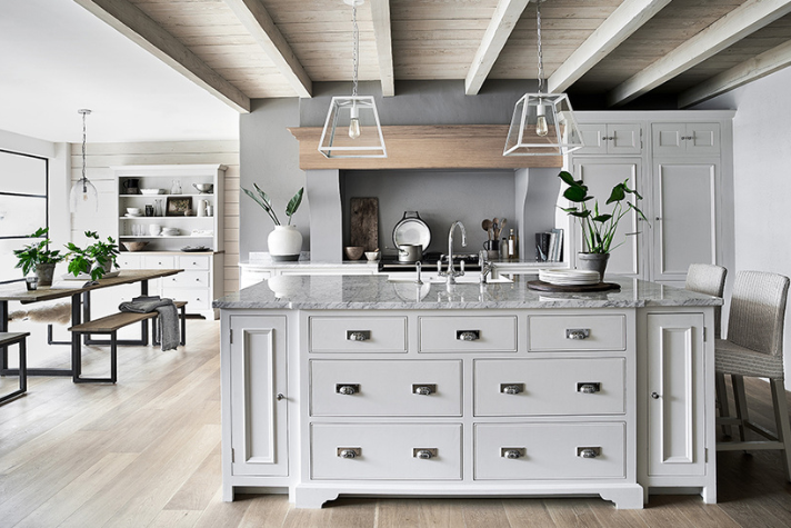 Moderne Landhausküche mit Kücheninsel und Holzdecke Helle, moderne Landhausküche mit zentraler Kücheninsel, Holzbalken-Decke, Esstischbereich und stilvoller Dekoration