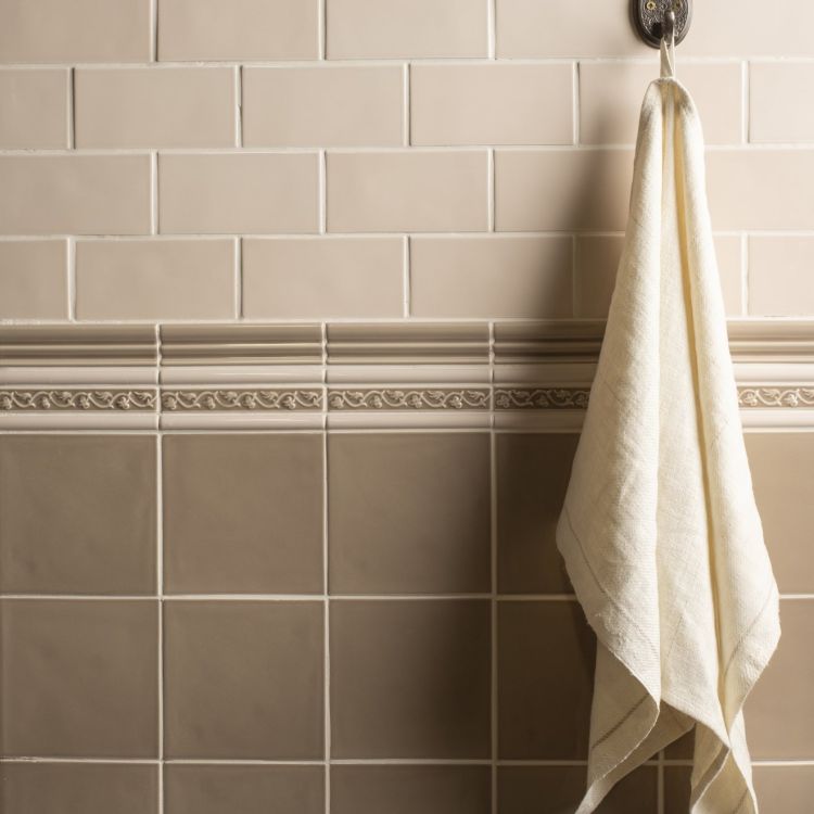 Beige Badfliesen mit Dekorleiste und Handtuch