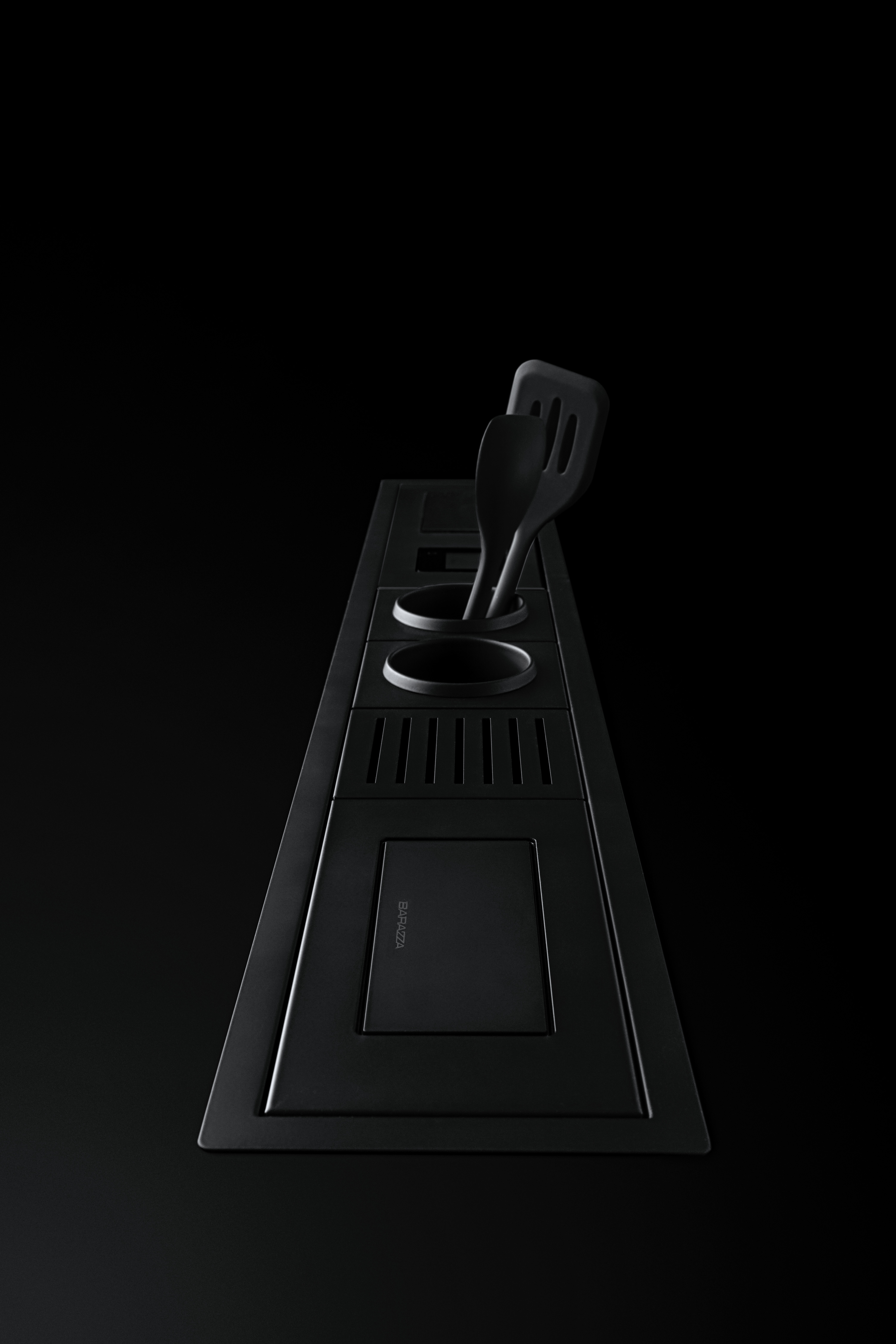 Modernes schwarzes Küchensystem mit Besteckeinsätzen und Küchenutensilien auf schwarzer Arbeitsfläche Schwarzes, modernes Küchensystem mit integrierten Besteckeinsätzen und zwei schwarzen Küchenutensilien, minimalistisch auf schwarzem Untergrund präsentiert