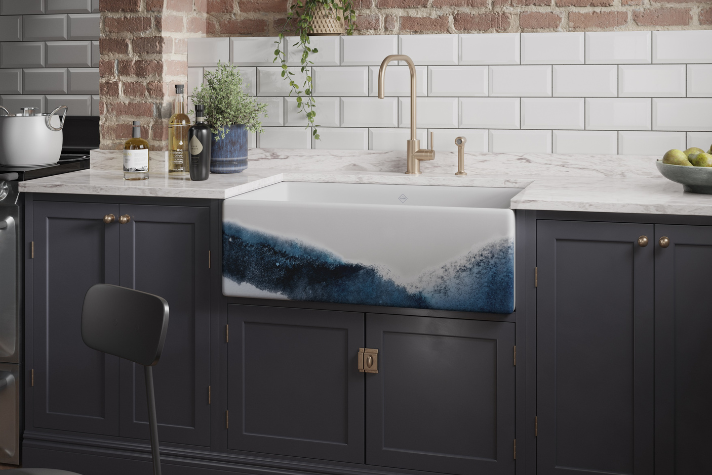 Moderne Küche mit Design-Spülbecken im Ozean-Look und goldener Armatur, Marmor-Arbeitsplatte Stilvolle Küchenspüle mit blau-weißem Wellendesign, goldener Wasserhahn, dunkle Schränke und Marmor-Arbeitsplatte in moderner Küche