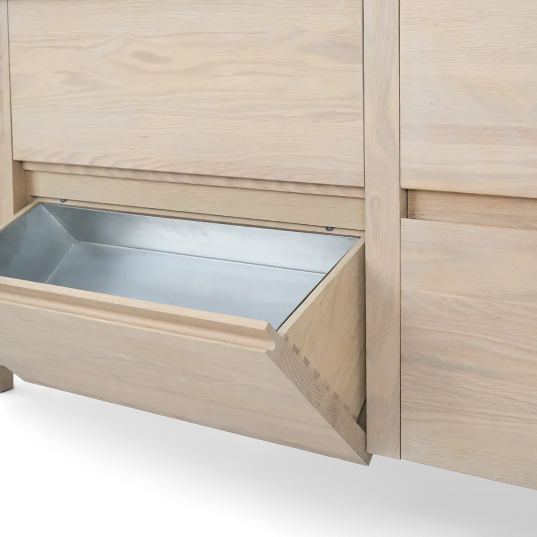 Detail eines hellen Holzschranks mit kippbarer Schublade und integrierter Metallwanne zur sauberen Aufbewahrung im Küchenschrank