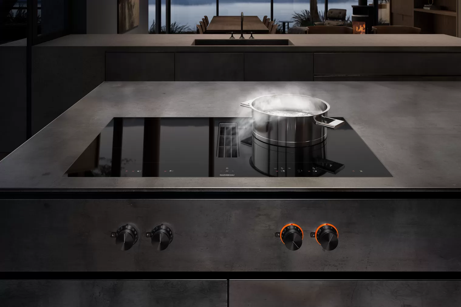 Modernes Induktionskochfeld mit integriertem Dunstabzug und Kochendem Topf in Design-Küche Ein Induktionskochfeld mit integriertem Dunstabzug in einer modernen Küche. Auf dem Kochfeld steht ein Topf mit kochendem Wasser, aus dem Dampf aufsteigt.