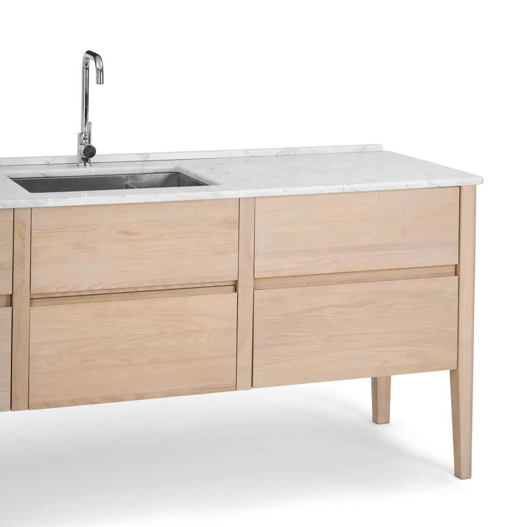 Helle Kücheninsel mit Holzfront, weißer Marmor-Arbeitsplatte, Edelstahl-Spülbecken und verchromter Armatur – bietet Stauraum und Arbeitsfläche für die Küche