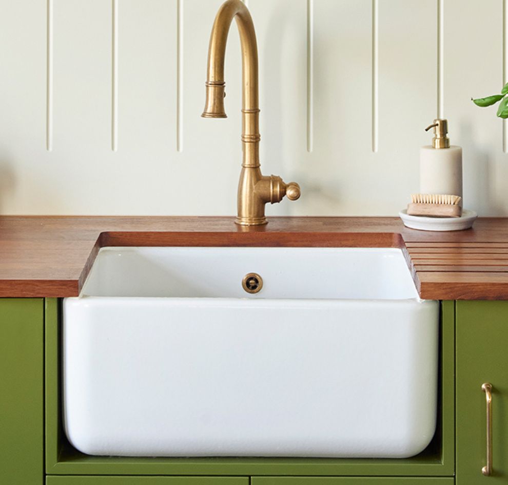 Weiße Landhaus-Spüle mit Messingarmatur und Holzplatte