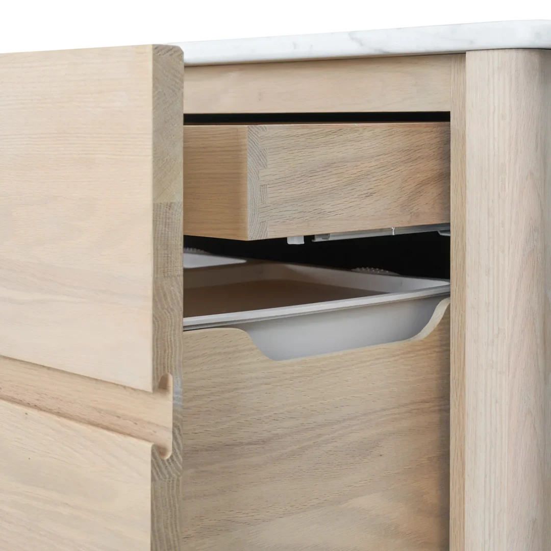 Detailansicht: Borough Spülenschrank von Neptune aus massiver Eiche mit Carrara-Marmorplatte; geöffnete Soft-Close-Abfallschublade/Innenschublade, passend für Spüle und Geschirrspüler – elegante, freistehende Küchenlösung.