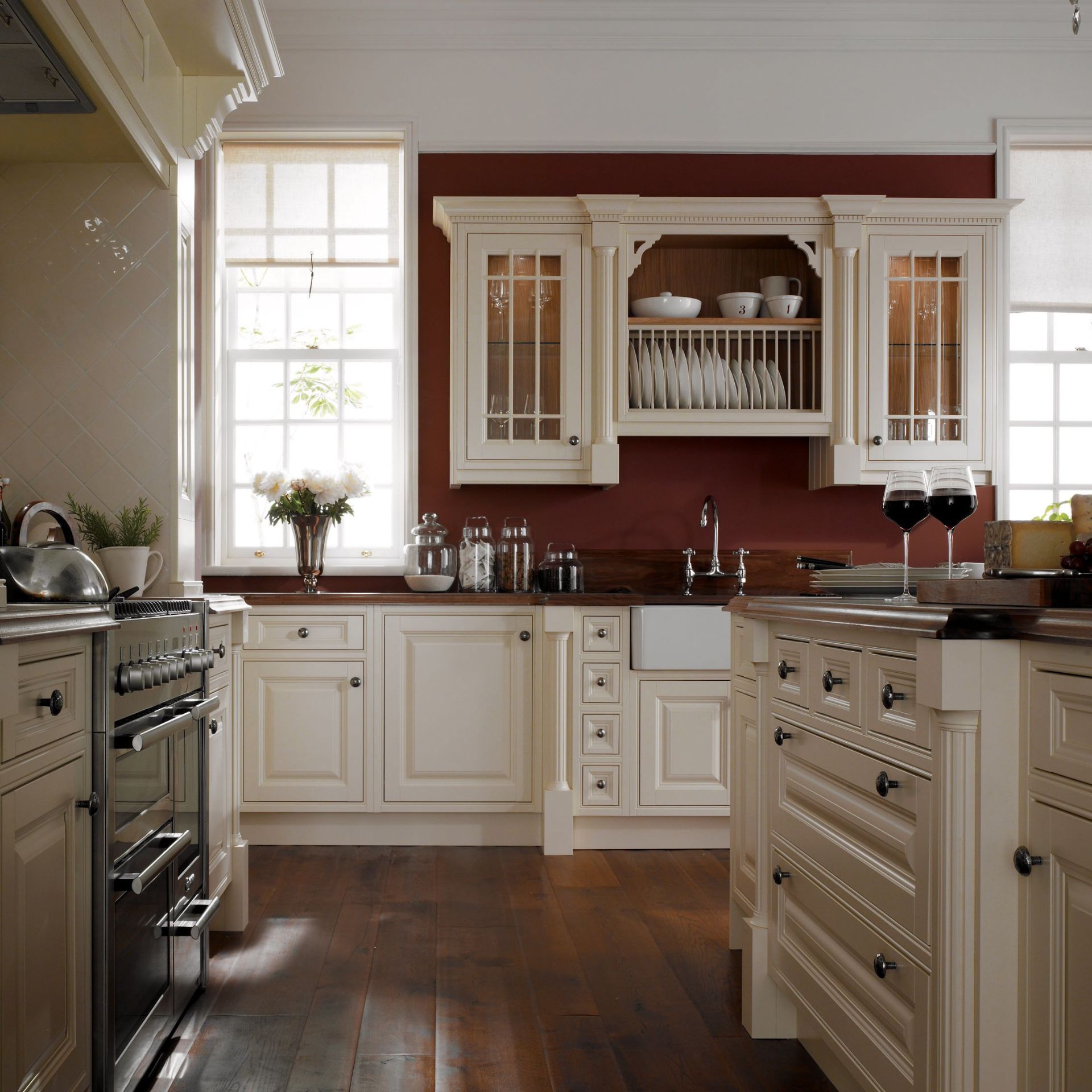 Elegante Einbauküche im Landhausstil in Creme mit Rahmenfronten, Tellerregal, Vitrinenschränken, Keramik-Spülbecken und dunkler Holz-Arbeitsplatte; ideal als komplette Küchenzeile
