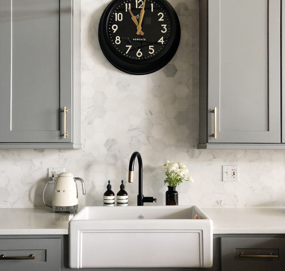 Graue Küche mit Hexagonfliesen, Uhr und Armatur schwarz