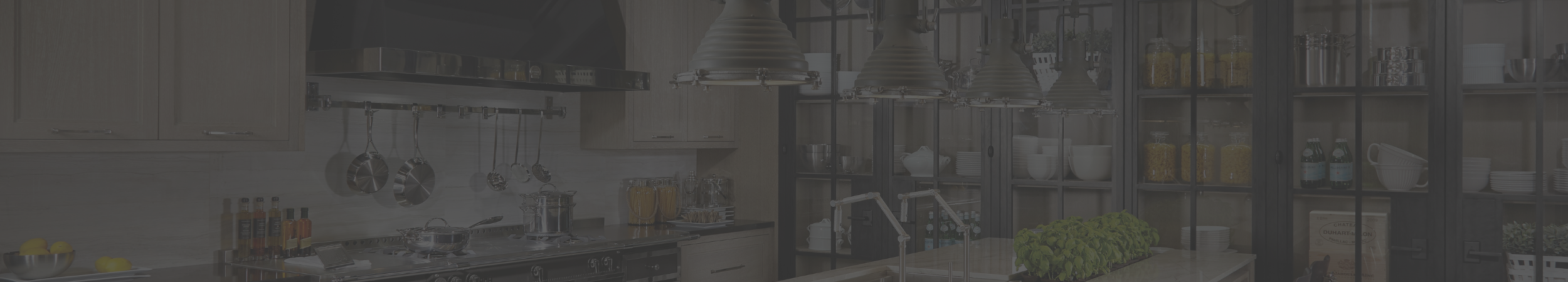 Moderne Küche mit Kochinsel, Hängelampen und offener Regalanlage Große, moderne Küche mit Kochinsel, Hängelampen, Töpfen, frischen Kräutern und offenem Regal mit Geschirr und Vorräten