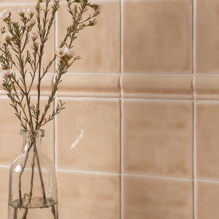 Beige Keramikfliesen, Glasvase mit Zweig davor