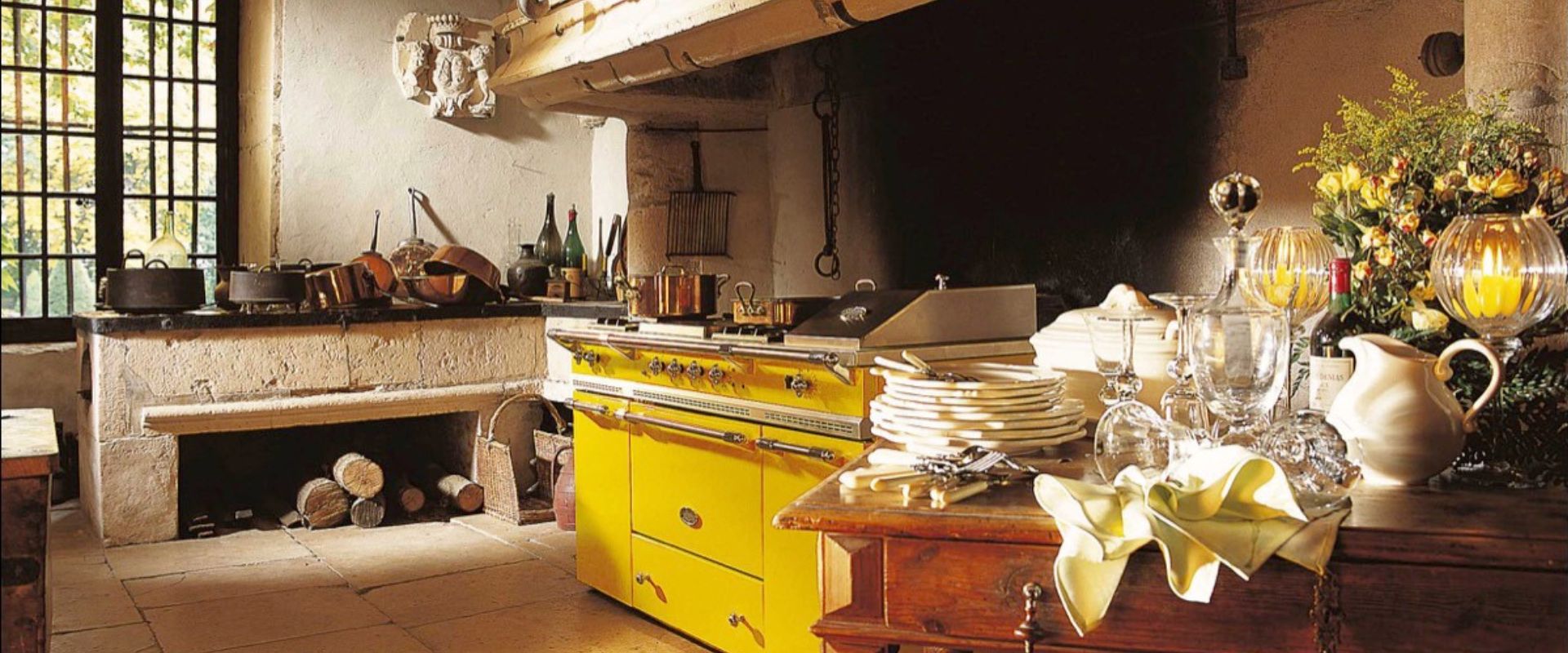 Gelber Retro-Standherd in rustikaler Landhausküche mit Kupfertöpfen auf der Kochfläche – hochwertiger Gasherd für die Design- und Genussküche