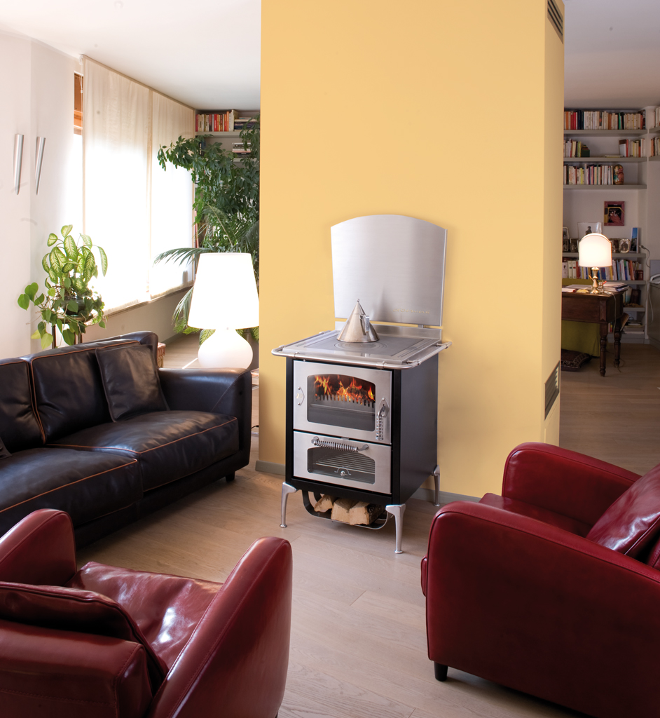 Gemütliches Wohnzimmer mit Holzofen und modernen Ledersofas Modern eingerichtetes Wohnzimmer mit schwarzem Holzofen, zwei roten und einem schwarzen Ledersofa, gelber Wand und viel Tageslicht